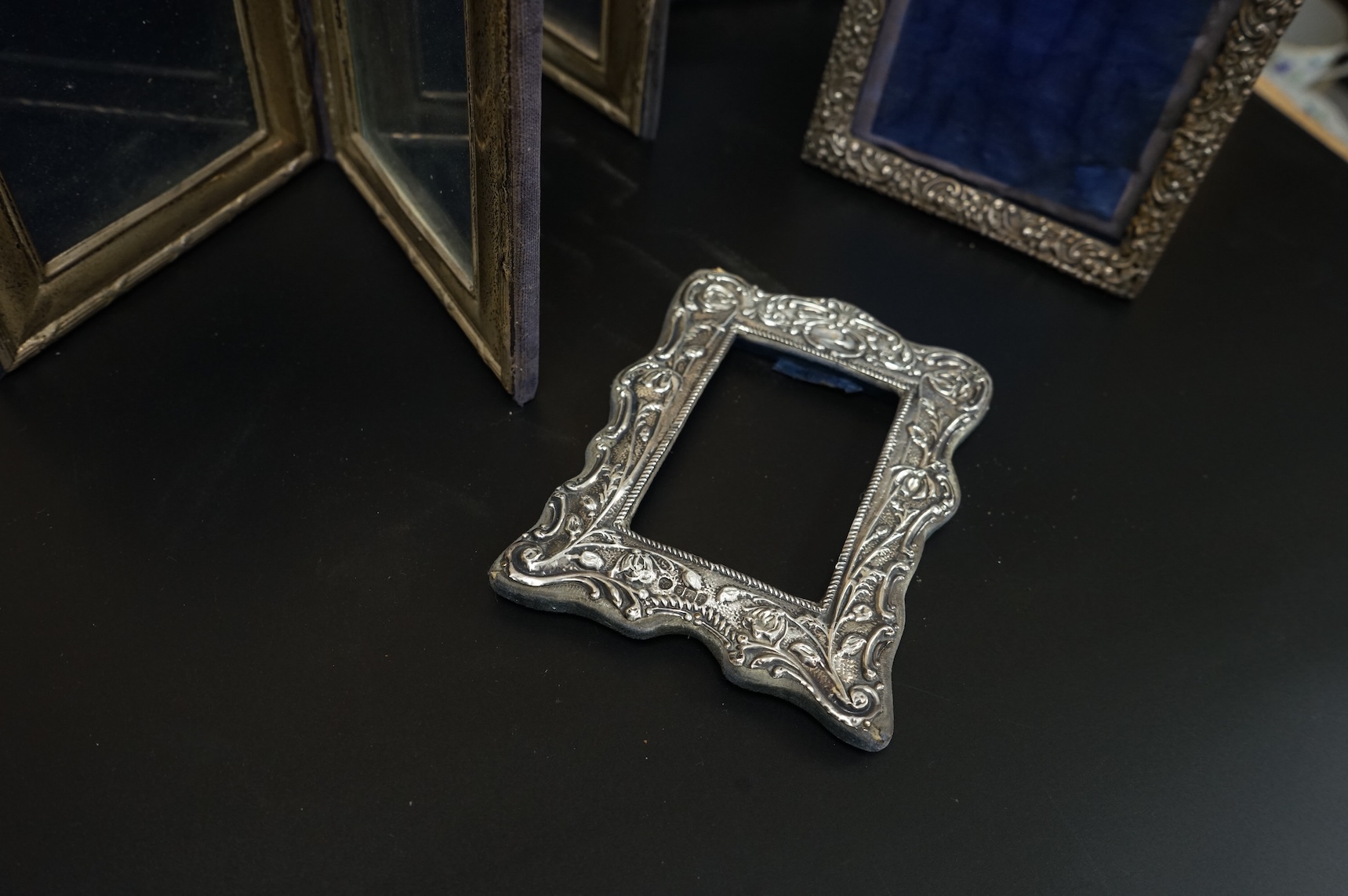 A late Victorian repousse silver mounted rectangular photograph frame, Birmingham, 1898, 17.9cm, a smaller Edwardian silver mounted photograph frame, Williams Ltd, Birmingham, 1905 and a set of four modern silver mounted
